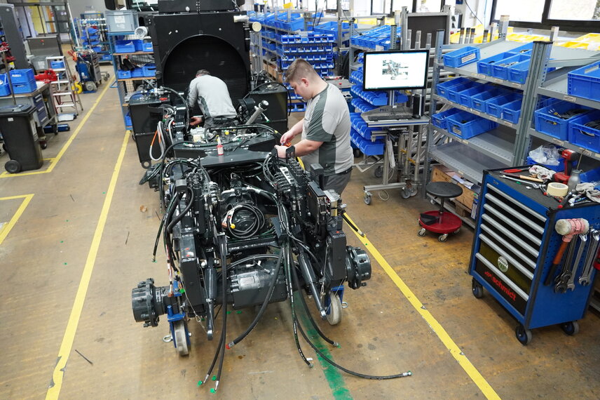 Computer stations support colleagues in the assembly of project-based airport equipment